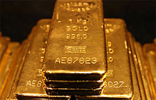 Shiny gold bars are stacked on top of each other in the shape of a pyramid. Shiny gold bars are stacked on top of each other in the shape of a pyramid.
