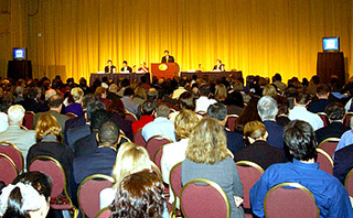 Speaker presenting to a large audience. Speaker presenting to a large audience.