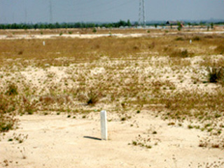 White boundary stones in an arid landscape, marking the boundary between public and private land.